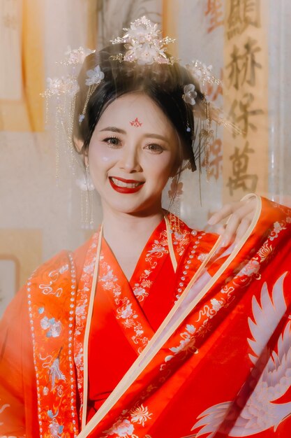 Foto vestido de mujer china retrato de año nuevo de una mujer en traje tradicional mujer en vestido tradicional hermosa mujer joven en un vestido rojo brillante y una corona de reina china posando