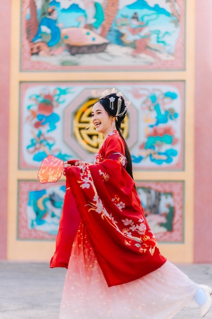 Foto vestido de mujer china retrato de año nuevo de una mujer en traje tradicional mujer en vestido tradicional hermosa mujer joven en un vestido rojo brillante y una corona de reina china posando