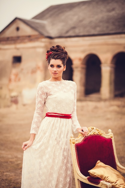 Vestido de niña de pie cerca de una silla