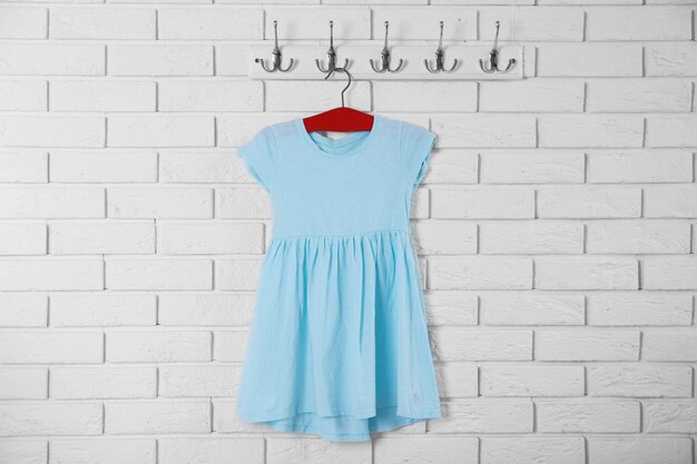 Vestido de niño en percha sobre fondo de pared blanca