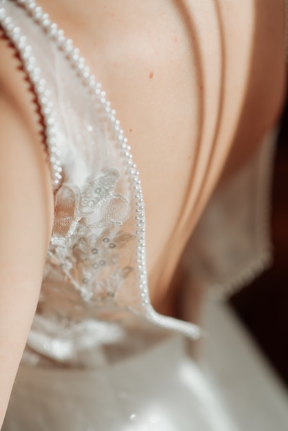 Vestido de novia blanco sobre la espalda descubierta de la novia