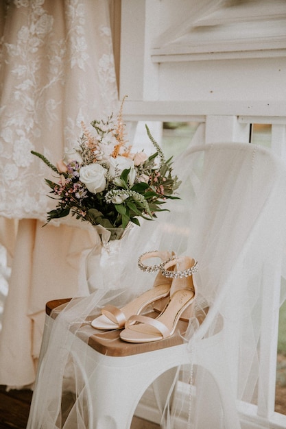 Vestido de novia flores y zapatos en una silla afuera