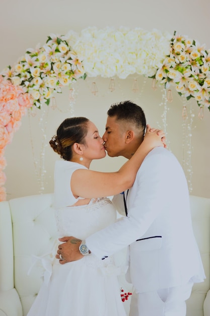 vestido de novia de pie en el jardín cerca de hermosas plantas sonriendo