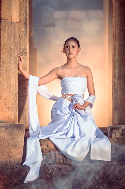 Vestido tradicional de mujer caminando por el castillo khmer.