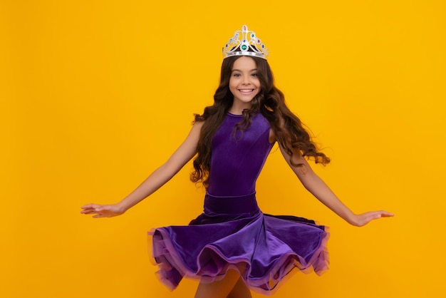 Vestido ventoso de movimento Beleza adolescente rainha usa coroa Criança em diadema de princesa Garota feliz enfrenta emoções positivas e sorridentes