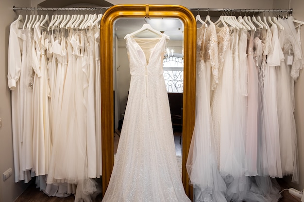 Vestidos de novia colgados en una percha. Look de moda. Interior del salón de novia.