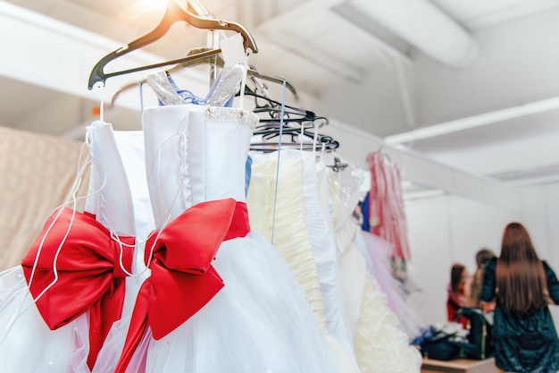 Vestidos de novia en exhibición con un gran lazo rojo