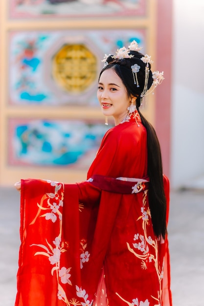 Vestuário de mulher China retrato de ano novo de uma pessoa de mulher em traje tradicional mulher em traje tradicional bela jovem em um vestido vermelho brilhante e uma coroa de rainha chinesa posando