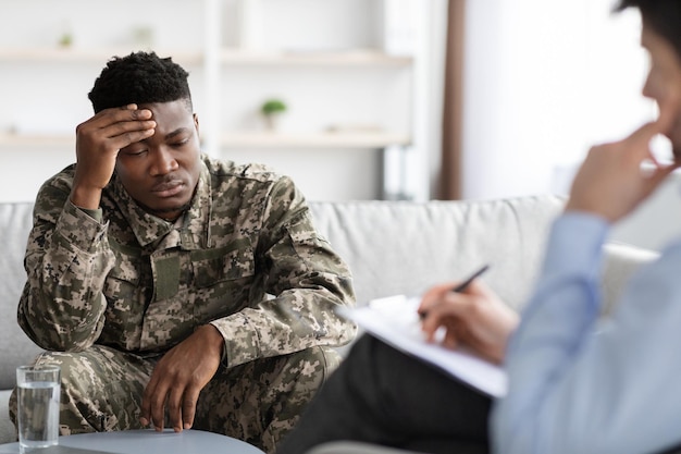 Veterano afro-americano chateado atendendo psicoterapeuta na clínica