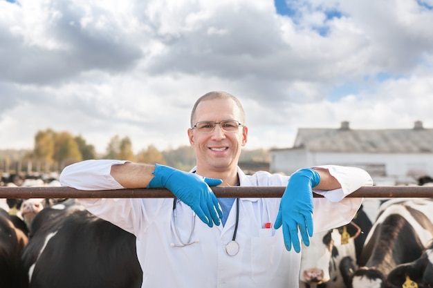 Veterinario masculino positivo en uniforme médico en la granja