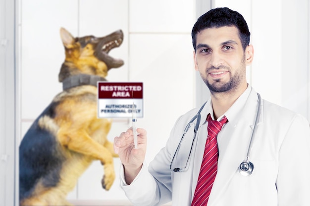 Foto veterinario de sexo masculino que sostiene una inyección con el perro enfermo