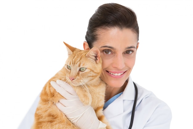 Veterinario sonriente con un gato en sus brazos