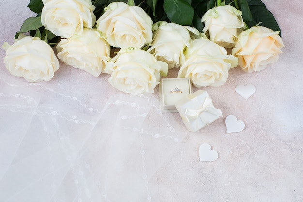 véu, anel, corações de cetim brancos e um buquê de rosas brancas