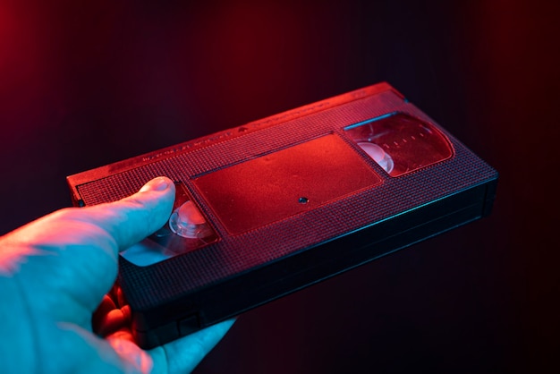 VHS-Kassettendetail bei dunklem Licht in die Hand genommen