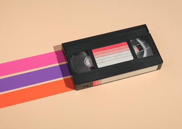 Foto vhs-videokassette auf pastellfarbenem hintergrund mit farbigen streifen minimalistische retro-komposition