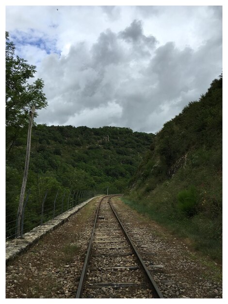 Foto la vía del ferrocarril contra el cielo nublado