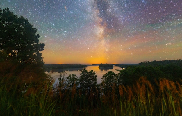 Vía Láctea brillante sobre el lago, disparo nocturno