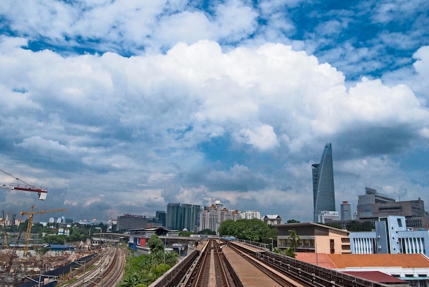 Una vía de tren con un cielo azul y un edificio al fondo