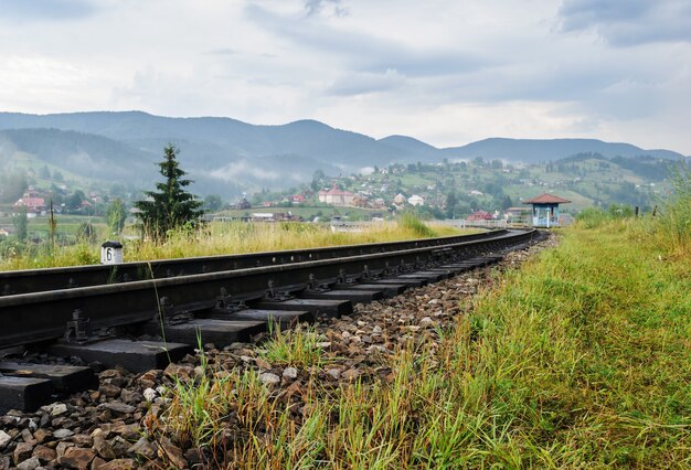 La vía del tren en el fondo de las montañas y el pueblo.