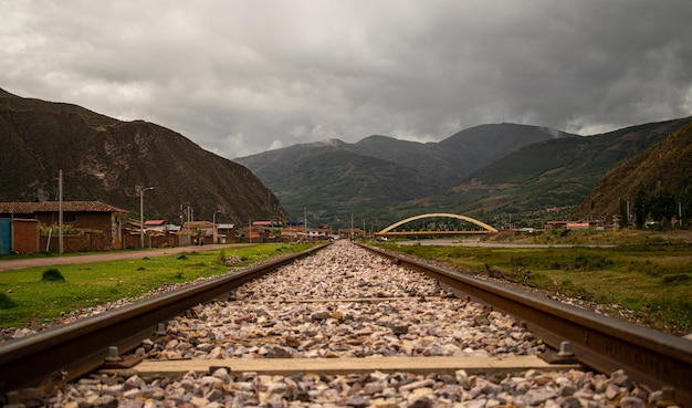 Una vía de tren con un puente al fondo.