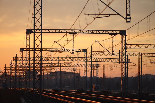 Una vía de tren con una puesta de sol de fondo