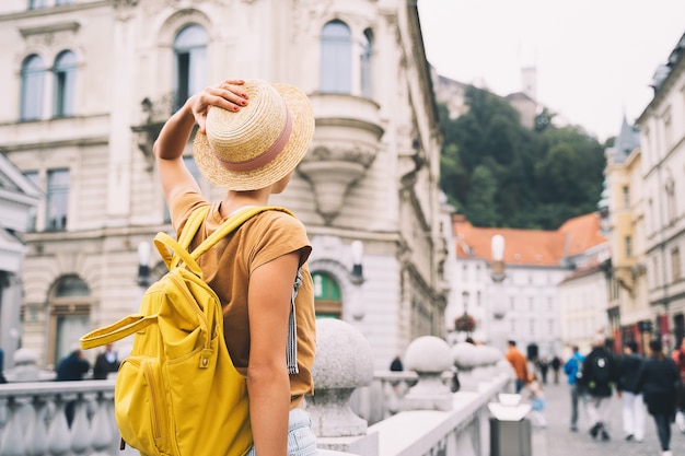 Foto viagem à eslovênia, europa jovem com mochila na ponte tripla, no coração da cidade velha de ljubljana