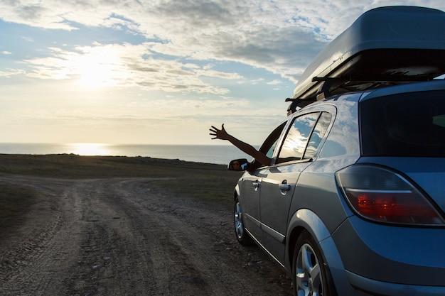 Foto viagem ao mar de carro, a garota estendeu a mão