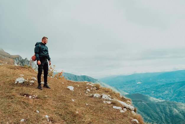 Viagem de aventura de jovem no topo do penhasco da montanha