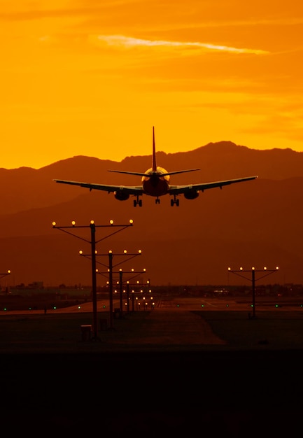 Viagem de avião ao pôr-do-sol Aterragem de avião de passageiros em Las Vegas, Nevada, durante o pôr- do-sol cênico