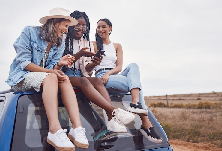 Foto viagem de carro e amigos felizes com postagem de mídia social por telefone e aventura no campo no espaço de maquete do céu grupo da áfrica do sul ou mulheres de diversidade 5g smartphone e telhado para viagem juntos