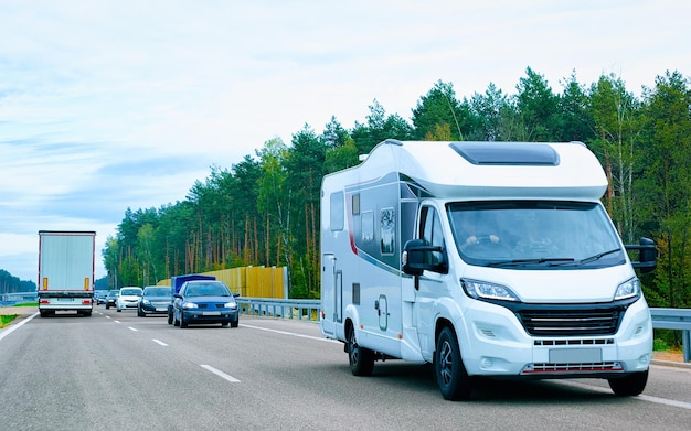 Viagem de férias com Caravan Car na estrada. Campista e passeio de verão na estrada. Viagem de férias em motorhome rv para recreação. Passeio de movimento de minivan de motor home na natureza. Cenário com veículo mini van.