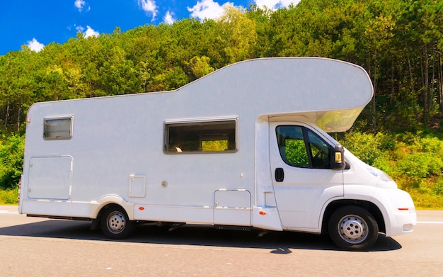 Viagem de férias com Caravan Car na estrada. Campista e passeio de verão na estrada. Viagem de férias em motorhome rv para recreação. Passeio de movimento de minivan de motor home na natureza. Cenário com veículo mini van.