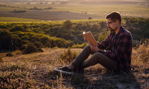 Viagem de homem relaxa nos assentos de férias relaxa lendo livros em penhascos rochosos