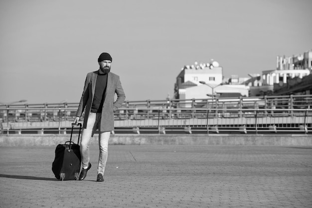 Viagem de negócios homem barbudo hipster viagem com grande bolsa de bagagem sobre rodas deixe a viagem começar viajante com mala chegar à estação ferroviária do aeroporto hipster pronto aproveite a viagem leve a bolsa de viagem