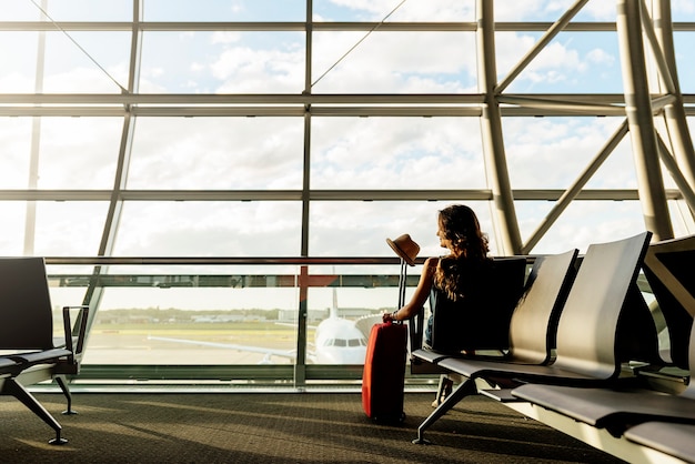 Viagem jovem andando com mala de porão de transporte no aeroporto. Conceito turístico.