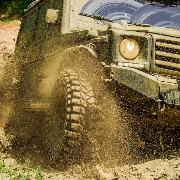 Viagem offroad no conceito de viagem de estrada de montanha com lama de carro grande x e respingos de água em corridas offroad ...