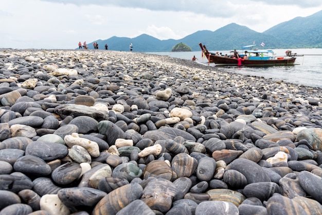 Viagem pelo Mar de Andaman até a ilha Ko Hin Ngam e a chegada de turistas em um barco de cauda longa e a bela natureza da rocha com estranha cor preta no Parque Nacional de Tarutao, Satun, Tailândia