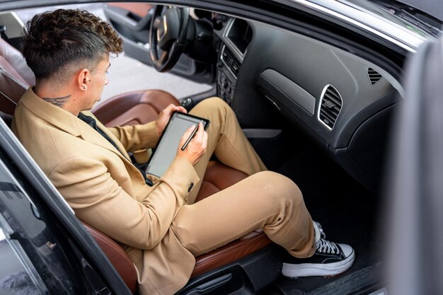 Viagens de negócios internacionais Jovem empresário de terno usando um tablet