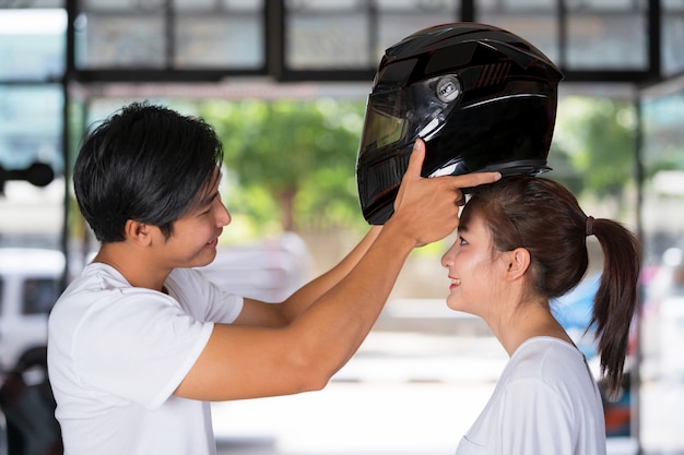 Viajando casal em pé e usando um capacete de moto