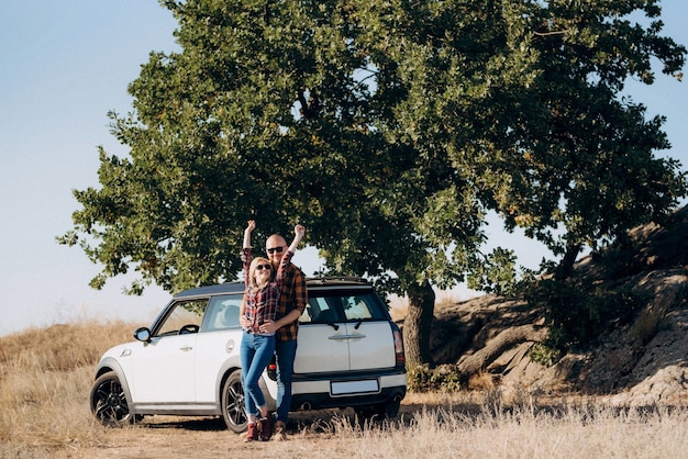 Viajando en coche de una joven pareja de un chico y una chica con camisas a cuadros