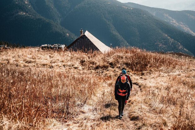 Viajante caminhando com mochilas Caminhando nas montanhas Paisagem ensolarada Viajante turístico na maquete de vista de fundo High tatras eslováquia