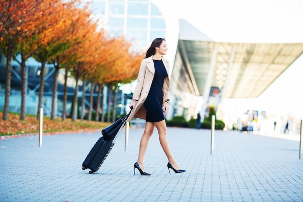 Viajante caminhando com sua bagagem perto do aeroporto