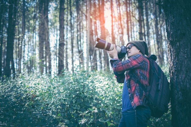 Viajante de homem com câmera fotográfica e mochila caminhadas ao ar livre estilo de vida de viagens e aventura