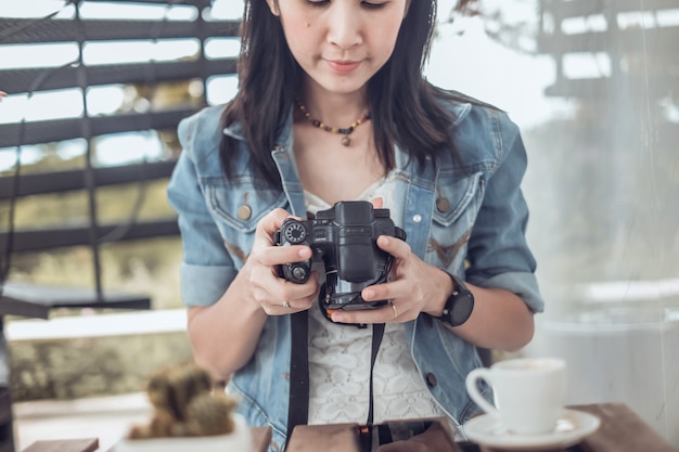 Viajante de mulher bonita Ásia bebendo café e olhando a foto na câmera