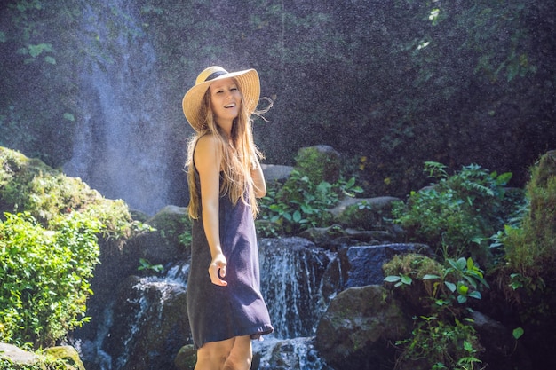 Viajante de mulher em um conceito de ecoturismo de fundo de cachoeira