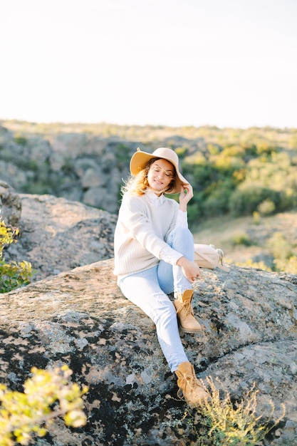 Viajante de mulher feliz no topo das rochas da montanha em dia ensolarado. caminhada na montanha