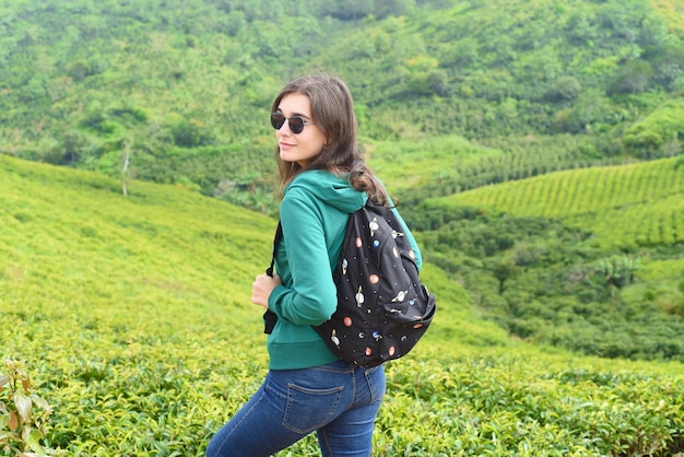 Viajante de mulher morena com mochila na colina de chá em Da Lat Vietnam