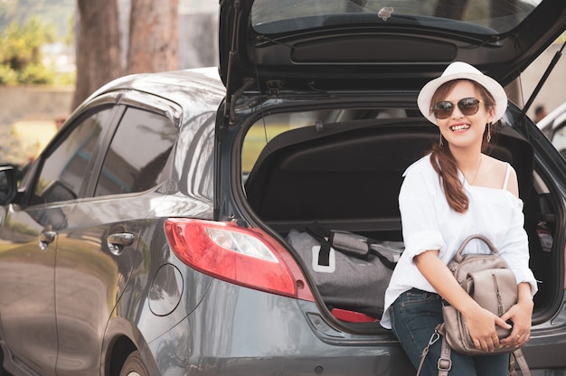 Viajante de mulher sentada no carro hatchback