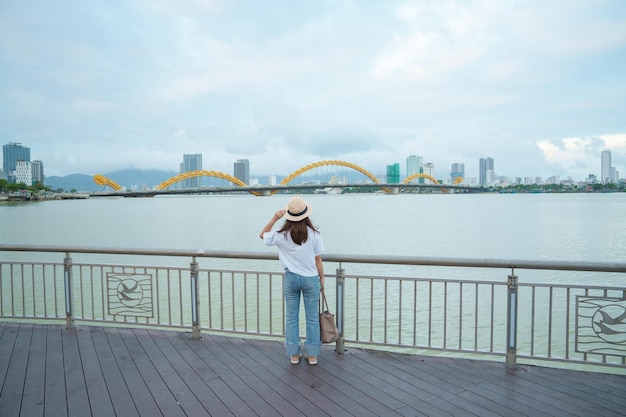 Viajante de mulher visitando a cidade de Da Nang Turismo turístico com vista para o rio com ponte do dragão Marco e popular para atração turística Conceito de viagem para o Vietnã e o Sudeste Asiático