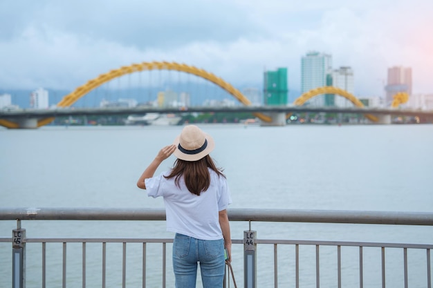 Viajante de mulher visitando a cidade de Da Nang Turismo turístico com vista para o rio com ponte do dragão Marco e popular para atração turística Conceito de viagem para o Vietnã e o Sudeste Asiático